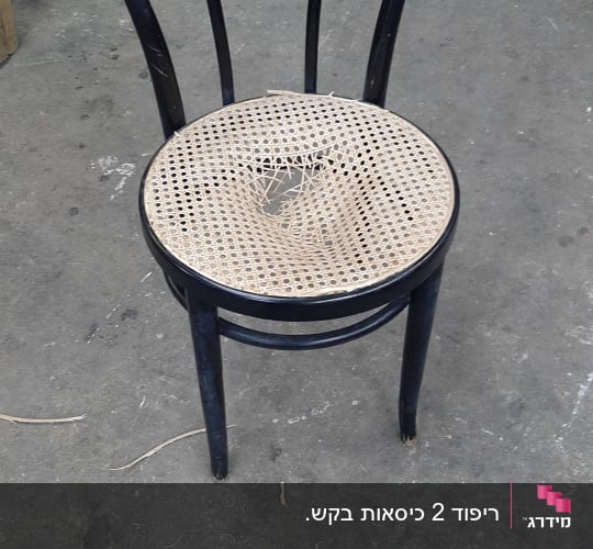 כיסא עם מושב קש קרוע על רצפת בטון